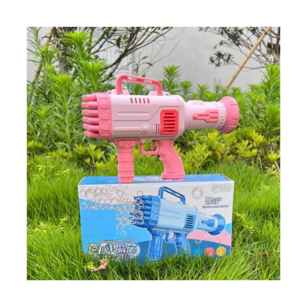 Bazooka pentru baloane de săpun, roz așezată pe cutia produsului, în iarbă.