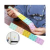 Benzi Fidget Squidopops XL, un copil în hanorac albastru întinde la masă o bandă Fidget în culori pastel; a doua bandă este