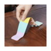 Benzi Fidget Squidopops XL, o mână de adult dezlipește de pe o masă de lemn o bandă Fidget cu segmente galben, mentă și lila
