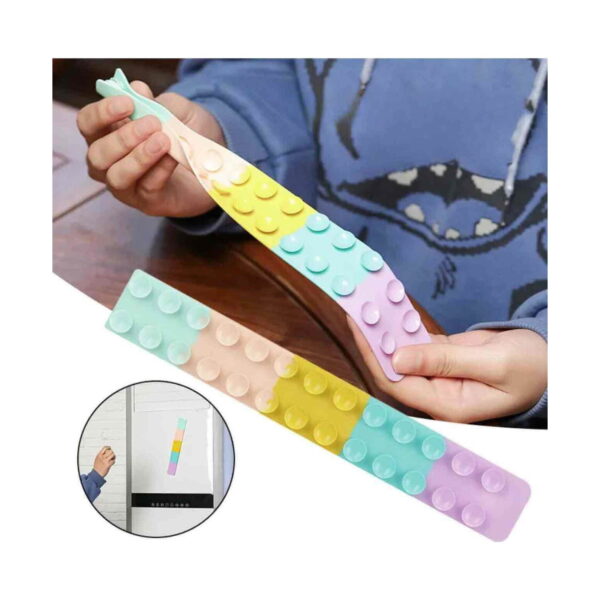 Benzi Fidget Squidopops XL, un copil în hanorac albastru întinde la masă o bandă Fidget în culori pastel; a doua bandă este