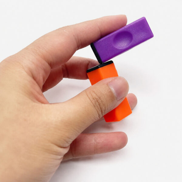 blocuri-magnetice-tik-tok-alb-si-portocaliu-utilizare-7 Blocuri magnetice Tik Tok, o mână ține un bloc magnetic mov rotit în unghi deasupra unui bloc portocaliu