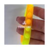 bratari-luminoase-fidget-fucsia-si-portocalii-detaliu Brățări luminoase Fidget, prim-plan cu o brățară translucidă portocaliu-galben, ținută între degete