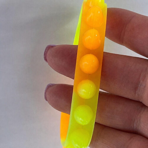 Brățări luminoase Fidget, brățară fidget cu bile galbene și portocalii, ținută între degetele unei mâini