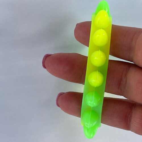 Brățări luminoase Fidget, brățară fidget cu bile galbene și verzi, ținută între degetele unei mâini