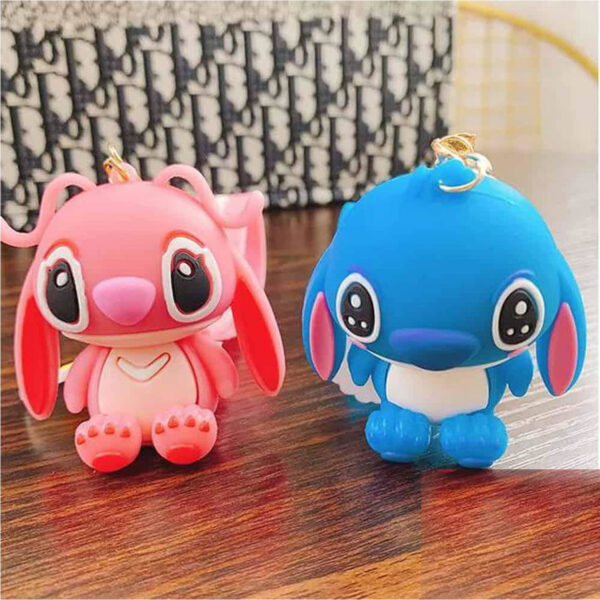 Breloc Lilo & Stitch, figurinele-breloc Angel roz și Stitch albastru așezate pe o masă de lemn