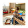 camion-de-transport-pentru-copii-cu-dinozauri-2 Camion de transport pentru copii cu dinozauri, un băiat îngenuncheat pe covor într-o cameră de copii se joacă cu camionul
