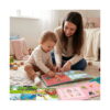 Carte educativă Montessori animale, o femeie și un copil mic stau pe covor și răsfoiesc împreună cartea deschisă
