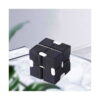 Cub Infinity, negru cu alb așezat pe o suprafață deschisă, lângă o plantă verde