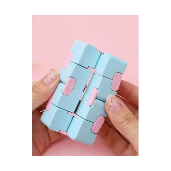 Cub Infinity Fidget, două mâini cu unghii manichiurate care răsucesc cubul infinit albastru cu roz, pe fundal roz