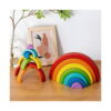 curcubeu-montessori-din-lemn-lifestyle Curcubeu Montessori din lemn, pe o masă din lemn, curcubeul complet imbricat în dreapta și un turn creativ din arcade