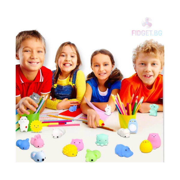 Găletușă Surpriză Fidget, patru copii zâmbitori la o masă, cu jucării squishy în formă de animale și creioane colorate