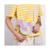 geanta-pop-it-mickey-mouse-15-15-cm-utilizare Geantă Pop It Mickey Mouse, persoană într-un tricou galben în dungi poartă geanta cu bretea pe umăr, pe lângă corp