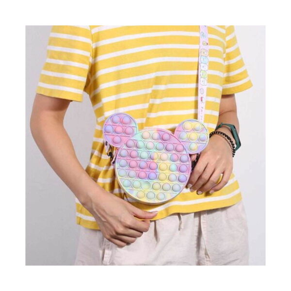geanta-pop-it-mickey-mouse-15-15-cm-utilizare Geantă Pop It Mickey Mouse, persoană într-un tricou galben în dungi poartă geanta cu bretea pe umăr, pe lângă corp
