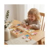 joc-educativ-iepurasii-veseli-utilizare-2 Joc educativ iepurașii veseli, copil blond, zâmbind la o masă din lemn, asamblând un iepuraș din piese de lemn