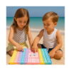 Joc Pop It cu zaruri, o fetiță și un băiat, pe plajă lângă mare, apasă bulele tablei pastel cu două zaruri în mijloc