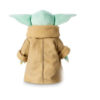 Jucărie de pluș Baby Yoda, văzut din spate, cu roba bej și gulerul maro, urechile mari verzi ieșind în lateral