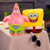 Jucărie de pluș SpongeBob, jucăriile Patrick (stânga) și SpongeBob (dreapta) așezate împreună pe o masă