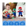 jucarie-de-plus-super-mario-albastra-si-rosie-utilizare Jucărie de pluș Super Mario, băiat așezat pe covor ținând jucăria de pluș Mario