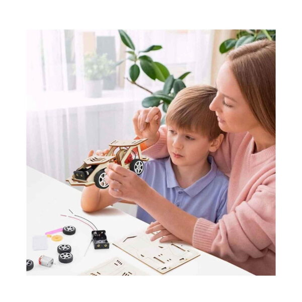 kit-stem-carucior-din-lemn-utilizare-5 Kit STEM Cărucior din lemn, o femeie și un băiat la o masă albă, ținând mașinuța aproape finalizată, cu roți, motor
