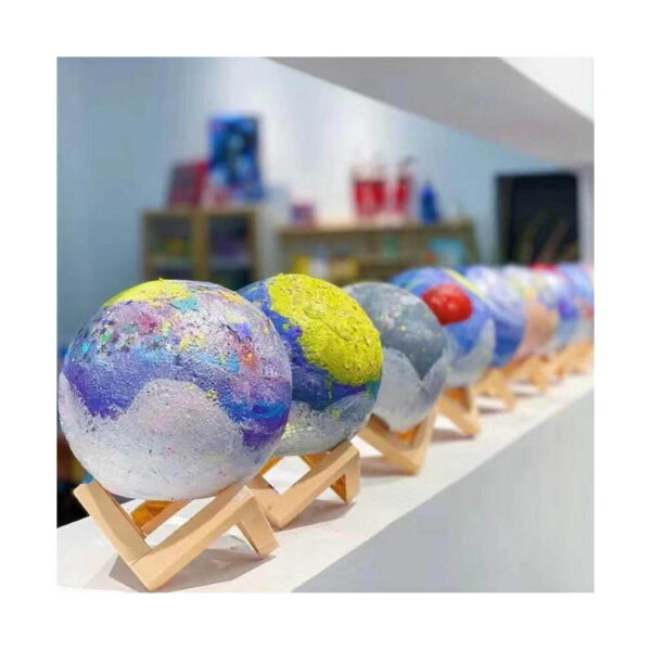 lampa-de-veghe-3d-luna-model-asamblat Lampă de veghe 3D lună, un șir de globuri pictate cu modele de planete, expuse pe suporturi mici din lemn, pe o poliță lungă