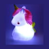lampa-de-veghe-unicorn-iluminat-2 Lampă de veghe unicorn, unicornul aprins pe fundal mov, cu coamă roz reliefată, corn auriu spiralat și aripi mici verzui