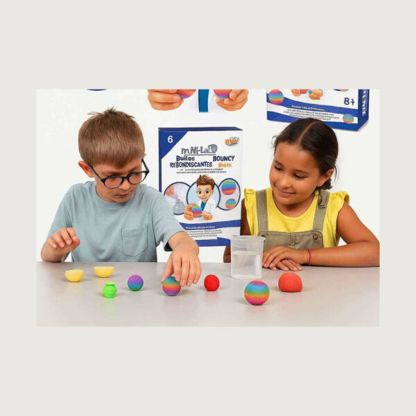 lume-steam-cu-bule-3-in-1-utilizare-2 Lume STEAM cu bule, doi copii la masă cu cutia Mini-Lab Bouncy Balls în spate, bile colorate, forme și un pahar