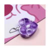 mini-pop-it-inimioara-detaliu Mini Pop It inimioară, prim-plan cu mini Pop It inimă mov, cu bulele apăsate, pe fundal roz