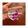 mini-pop-it-inimioara-dimensiuni Mini Pop It inimioară, inimă alb cu roz, cu lănțișor, ținut între degete deasupra unei mese de lemn