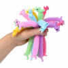 Monkey Noodles unicorn, o mână strânge un mănunchi des de jucării unicorn pastel, desfăcute în evantai în toate direcțiile