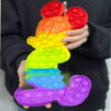 Pop It colorat Mickey Mouse 30x20, ținută în mâini, pe fundal de haină neagră