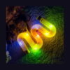 pop-tube-rosu-lifestyle-3 Tub Fidget Pop luminos XL, tuburi luminoase galbene și albe, aranjate pe covor în întuneric