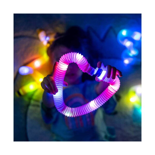 pop-tube-rosu-utilizare Tub Fidget Pop luminos XL, copil care îndoaie în întuneric un tub luminos roz-alb în formă de inimă