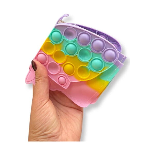 portofel-pentru-copii-fluture-curcubeu-dimensiuni-2 Portofel pentru copii Fluture, o mână ține portofelul pastel pliat, cu aripile Pop It în față