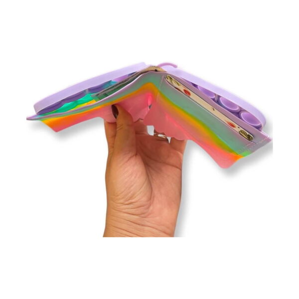 portofel-pentru-copii-fluture-curcubeu-lateral Portofel pentru copii Fluture, o mână ține portofelul pastel deschis, cu interiorul vizibil: sloturi pentru carduri și capsă