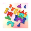 puzzle-pop-it-castel-continut Puzzle Pop It Castel, piese Pop It modulare împrăștiate pe fundal pastel și un castel parțial asamblat