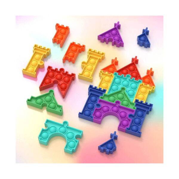 puzzle-pop-it-castel-continut Puzzle Pop It Castel, piese Pop It modulare împrăștiate pe fundal pastel și un castel parțial asamblat