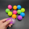 set-4-bile-sticky-balls Set 4 bile Sticky Balls, mai multe bile lucioase în culori diferite (roz, portocaliu, albastru, verde) pe o suprafață gri