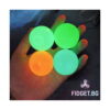 set-4-bile-sticky-balls-iluminat-2 Set 4 bile Sticky Balls, patru bile fosforescente (una portocalie, trei verzi) în palma unei mâini, în întuneric