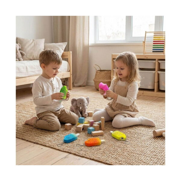 Set 5 squishy în formă de înghețată, un băiat și o fetiță pe covor într-o cameră de joacă; băiatul ține înghețata verde