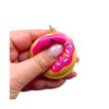 set-10-squishy-parfumate-fast-food-utilizare Set 10 squishy parfumate Fast Food, mână care strânge un breloc squishy gogoașă, cu glazură roz