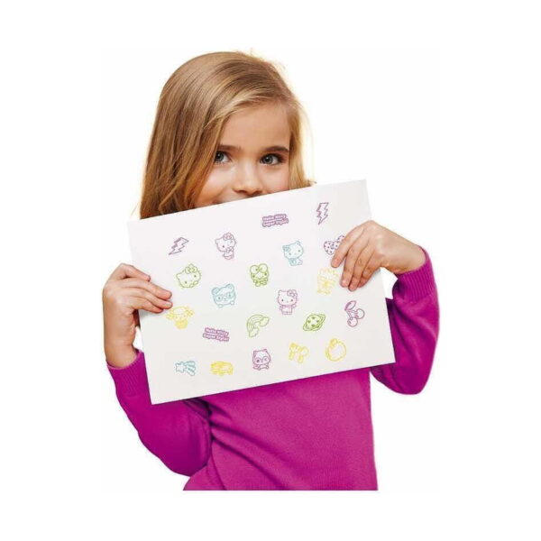 Set creativ Hello Kitty 3 în 1, fetiță în bluză roz ținând în fața feței o coală albă ștampilată cu personaje Hello Kitty