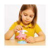 set-de-constructie-3d-hello-kitty-utilizare Set de construcție 3D Hello Kitty, fetiță la masă, pe fundal alb, asamblând unicornul roz din micro cărămizi