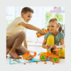 set-de-constructie-stem-technik-5-in-1-utilizare-3 Set de construcție STEM Technik 5 în 1, un băiat și o fetiță pe podea, care asamblează un vehicul portocaliu cu o șurubelniță