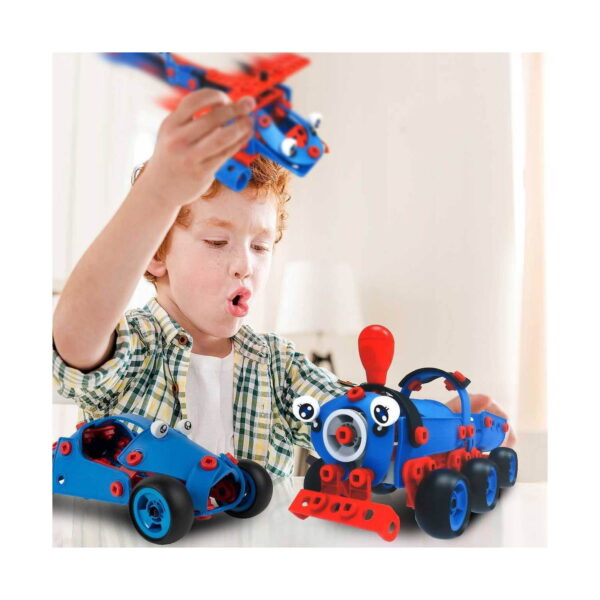 Set de construcție STEM Tineri inventatori, băiat roșcat care ridică deasupra capului avionul albastru cu aripi roșii