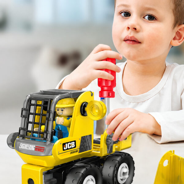 Set de construcție STEM utilaje 3 în 1, prim-plan cu un băiat care strânge cu o șurubelniță roșie un utilaj galben JCB