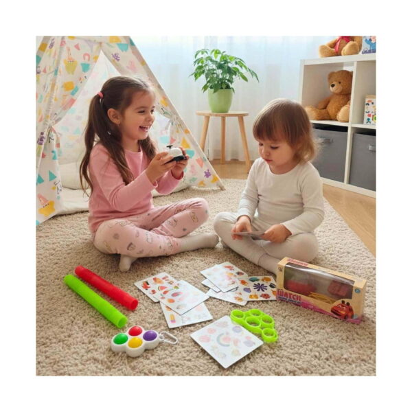 Set de jocuri educative, două fete pe covor, una ține soneria, cealaltă cărțile de joc; alături, tuburi extensibile