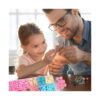 Set DIY de bijuterii cu unicorn, bărbat cu ochelari și o fetiță care confecționează bijuterii la masă
