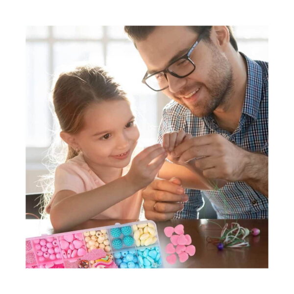 Set DIY de bijuterii cu unicorn, bărbat cu ochelari și o fetiță care confecționează bijuterii la masă