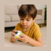 set-educativ-dino-utilizare-3 Set educativ Dino, un băiat în tricou galben ține în mâini bila-puzzle albă cu bile colorate