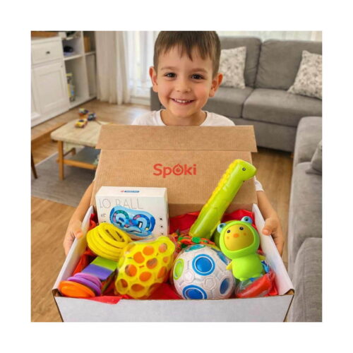 set-fidget-aventura-10-jucarii-antistres-utilizare Set Fidget Aventura, băiat care ține o cutie Spoki deschisă, plină cu jucării fidget: cutia IQ Ball, tub verde, lanț galben